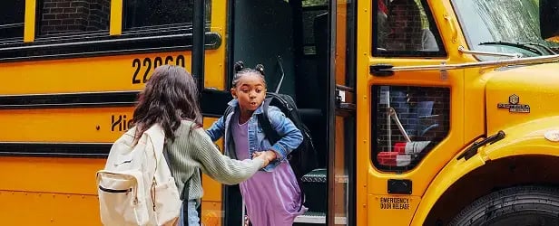 two children exiting a bus